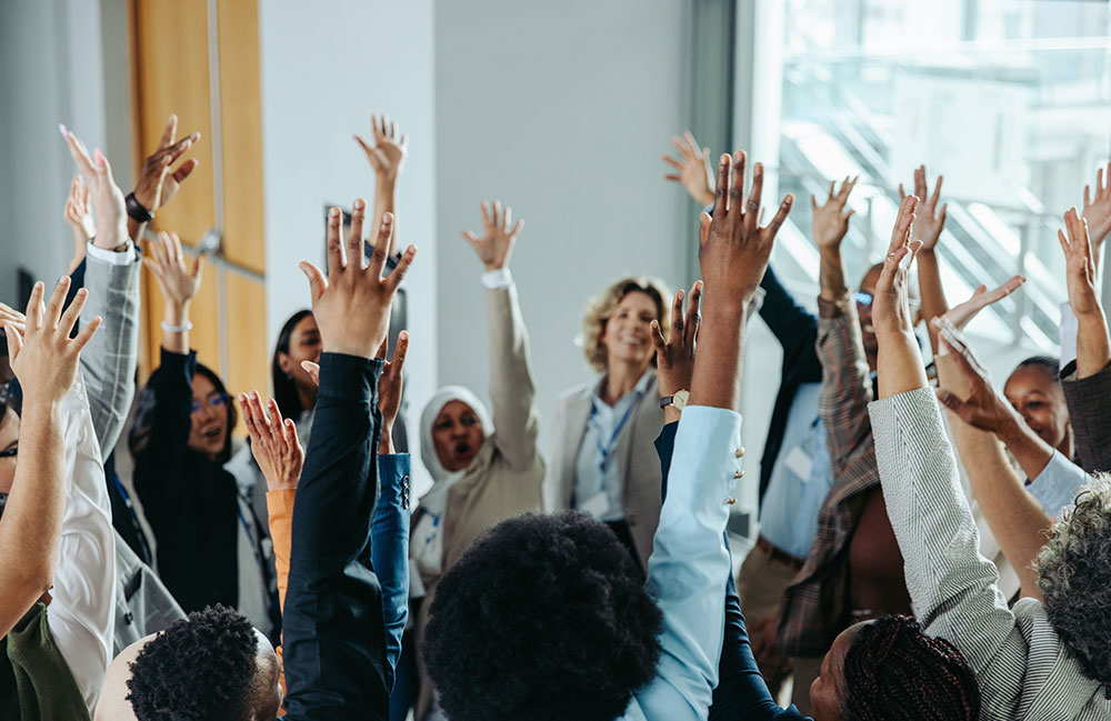 group of collaborative individuals with raised hands